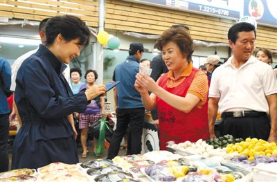 5日，韩国首尔，韩国总统朴槿惠在中秋前视察市场，购买过节食品。