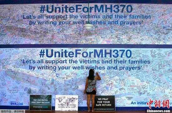 3月19日，马来西亚八打灵再也(Petaling Jaya)，民众在签名板上签名为马航MH370祈福