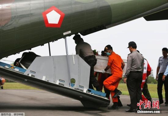 资料图：当地时间2015年1月19日，印尼庞卡兰布翁，依斯干达空军基地，救援队成员正将装有亚航失事飞机遇难者尸体的棺材抬上一架CN2950运输机。