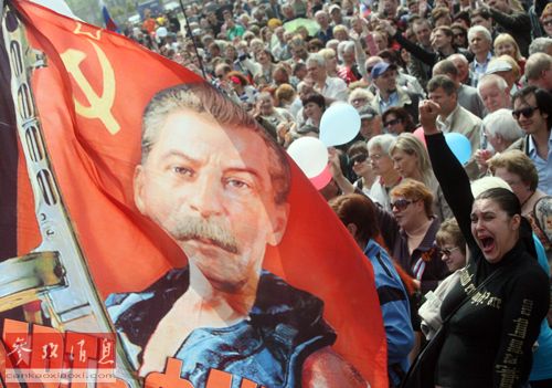 资料图片：乌东部顿涅茨克的亲俄民众高举绘有斯大林肖像的旗帜参加劳动节游行。