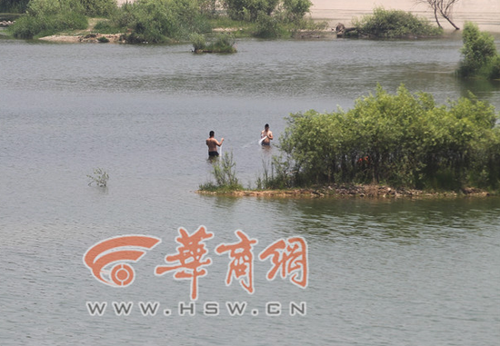 2014年7月6日，西安市灞柳西路的河边，不少市民在河里游泳