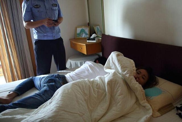 图为警方破门而入，抓住躺在床上的男子。