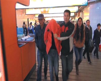 昨日下午，大兴警方在火车上控制抢劫金店的嫌疑人（红衣蒙头者）后带出北京站。