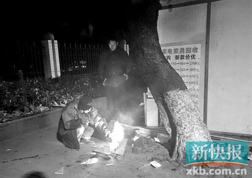 流花路旁,两名露宿者正在用柴火煮着冬至的晚餐。