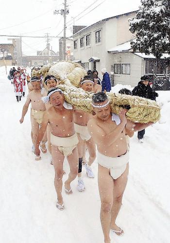 约40名日本男子冒雪抬年绳。