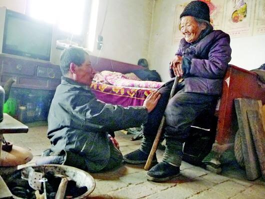 52岁的刘兰山每天靠爬行照顾90岁的老母亲。孙国祥 摄