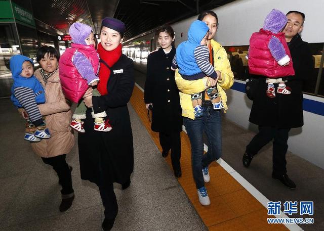 乘务员与四胞胎家属一同抱着孩子们