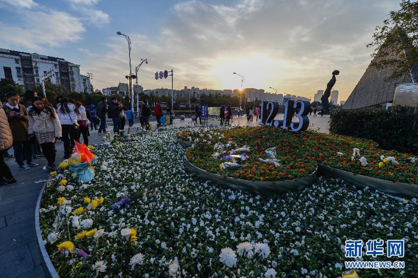 12月14日,观众在侵华日军南京大屠杀遇难同胞纪念馆前的“12·13”花坛上摆放鲜花祭奠遇难同胞。新华社记者 沈鹏 摄