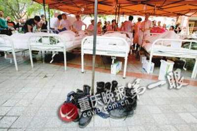 坠河战士正在帐篷医院接受救治，军靴摆了一地。