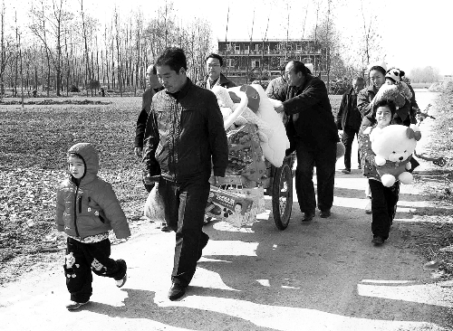 姐（左一）弟（右一护士怀中男婴）返乡，爱心捐赠满满一架子车。