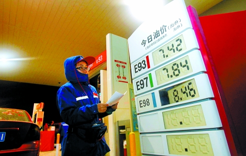 今日凌晨，郑东新区某加油站工作人员调整价格牌。