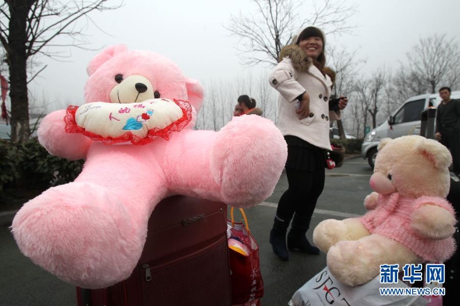江苏省如皋市一家娱乐用品公司的员工张艳带着毛绒玩具熊在河南商丘下车