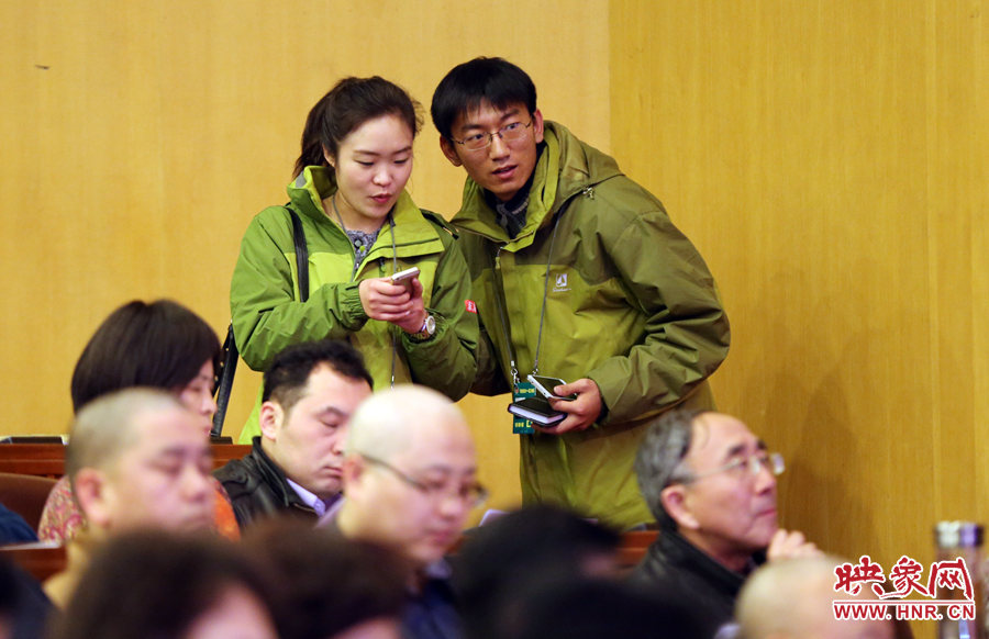 大象融媒体记者在政协会议现场商谈采访事宜。