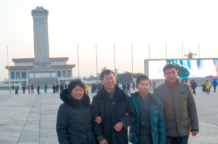 陈桂华（左1）搀扶着马俊欣(左2）和马俊欣的儿子在人民英雄纪念碑前合影