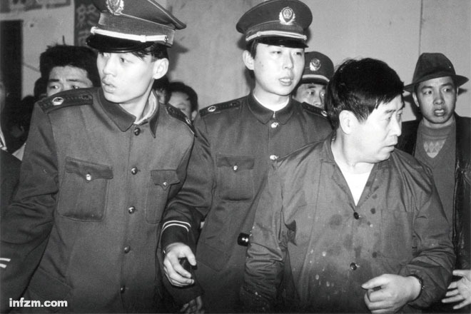 1997年，胡万林在陕西长安县太乙宫非法行医时给患者“带功”授课后被安保人员护送离去。 （CFP/图