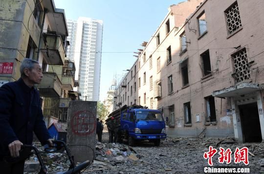 一位花甲老人站在即将拆除的楼房旁，默默地与“苏联楼”告别。　翟羽佳　摄