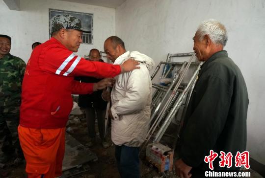 图为一名工人试穿刚刚领到的一件棉衣。　