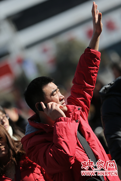 "一位旅客向同伴招手示意.